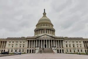 The united states capitol building stands under a cloudy sky.